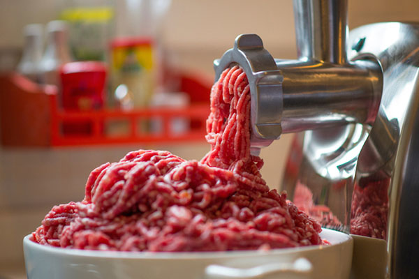 چرخ کردن گوشت برای تهیه همبرگر دست ساز